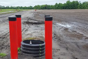 Photograph of a farm field with pipes in the foreground