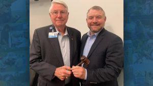 Douglas Burnett handing over a gavel to Rob Bradley