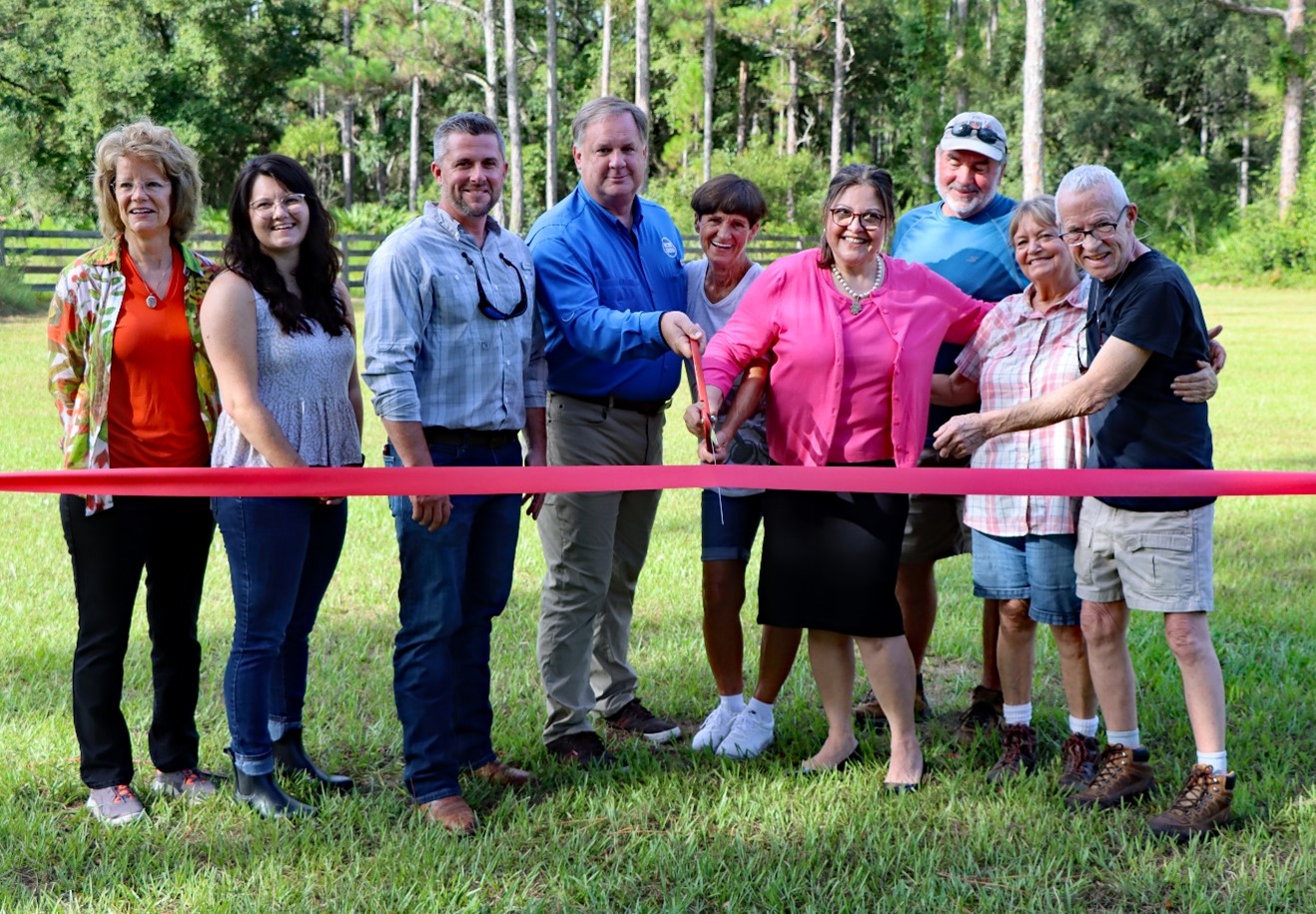 Group of people cutting a ribbom