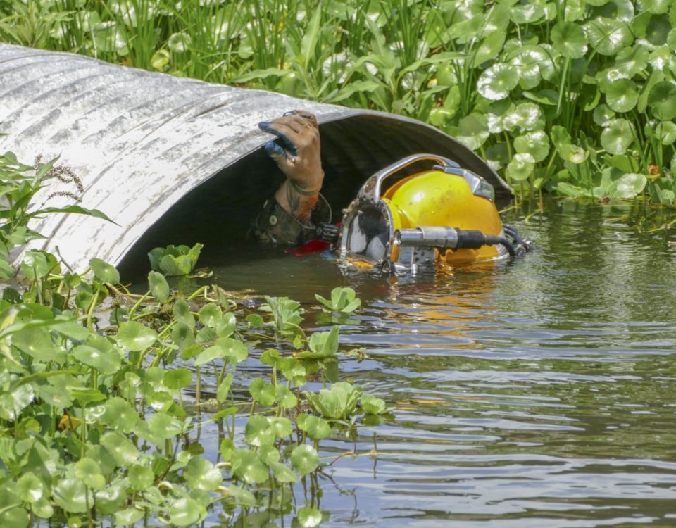 A diver inspecting a large culvert