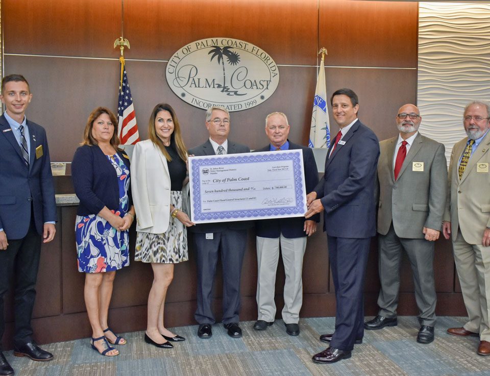 Jim Troiano and the City of Palm Coast Commissioners with a cost-share check