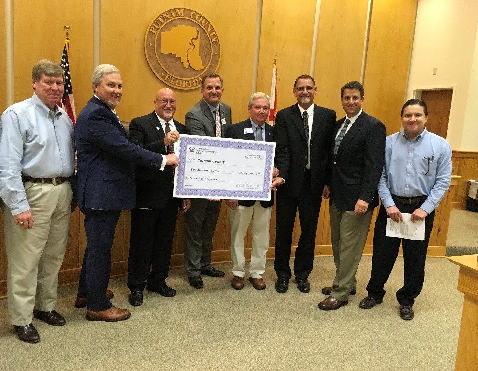 Jim Troiano and Putnam County commissioners and staff with a cost-share check at a commission meeting