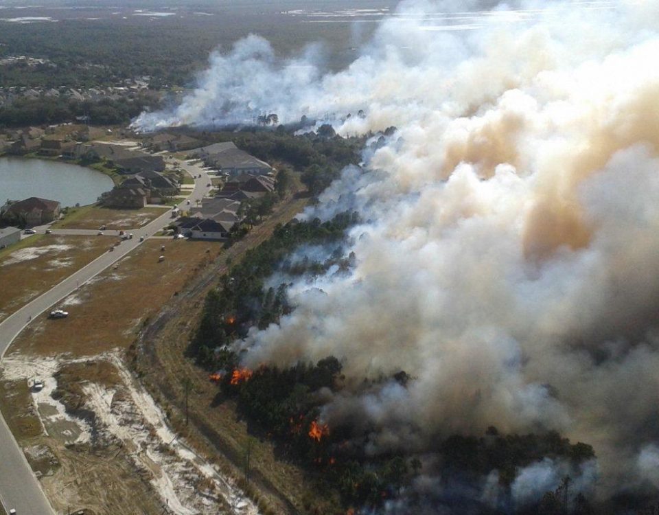 Aerial of a prescribed fire burning next to a neighborhood