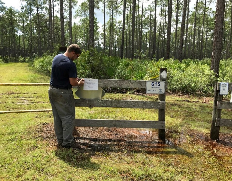 District staff putting up property closure notice on entrance to conservation area