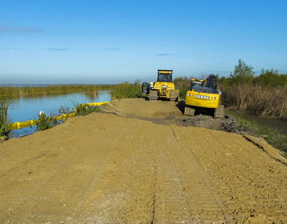 Tractors working to stabilize a levee along Lake Apopka