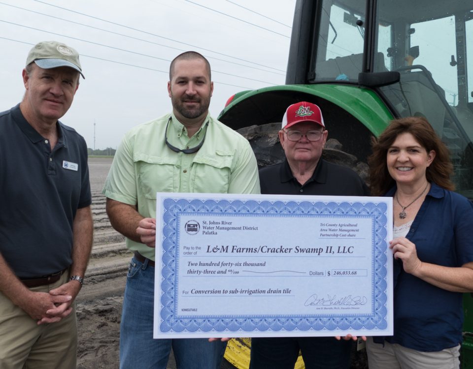 District staff presenting cost-share check to farmers at thier farm