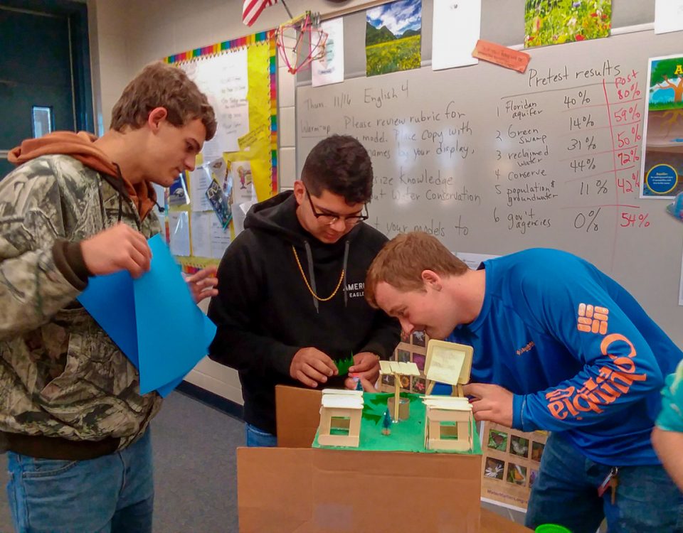 High school students in a classroom working on a model