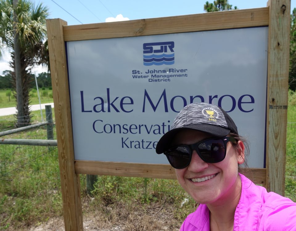 Selfie of a woman in front of the Lake Monroes Conservation Area entrance sign