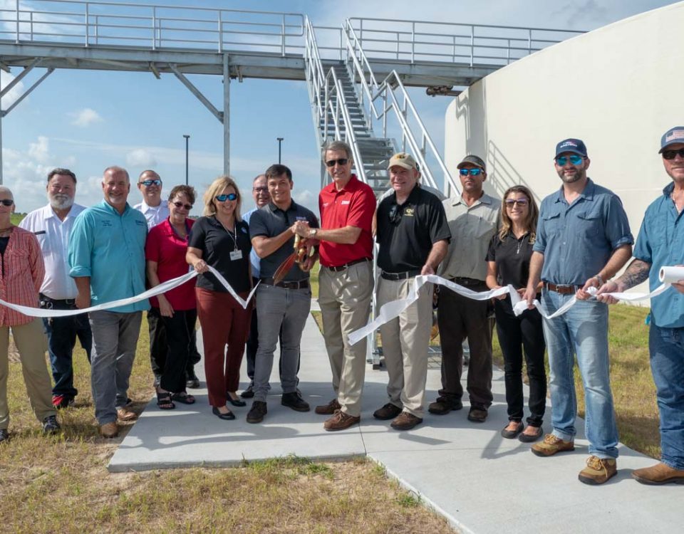 Lisa Kelley and shreholders cutting the ribbon at the Eustis Wastewater Treatment Plant Ribbon Cutting Event