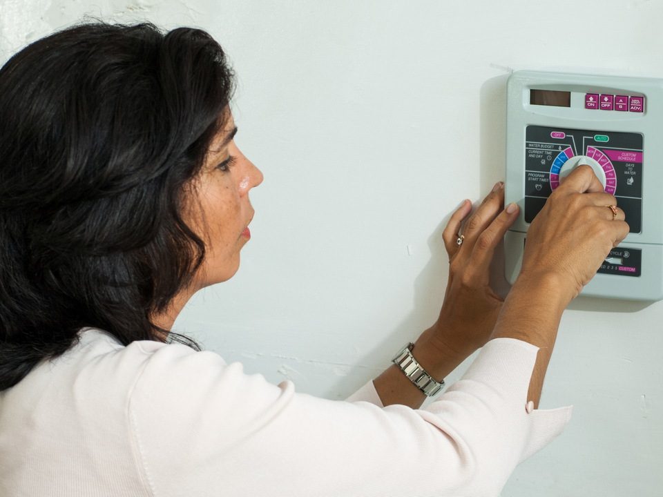 Woman adjusting an irrigation timer