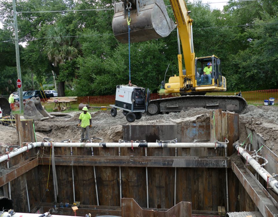 Excavator lowering equipment into a stormwater baffle box