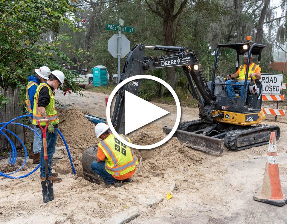 Four district employees working it a hole to fix water pipes