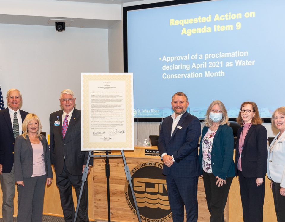 Governign board members with poster sized water conservation month proclamation