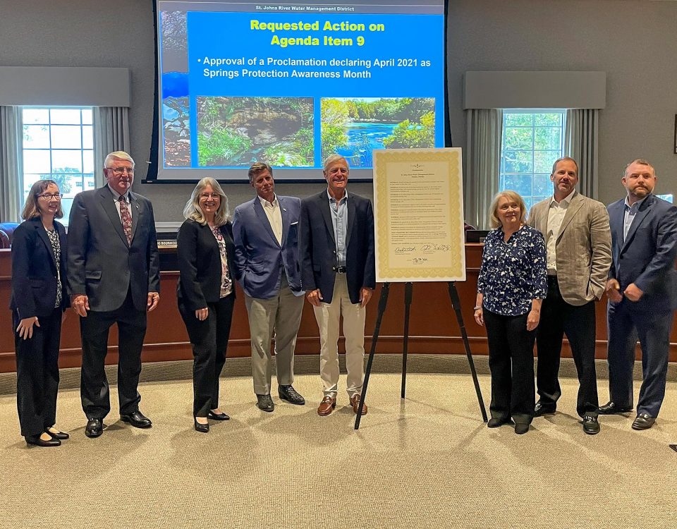 Board members and Dr, Shortelle standing around a tripod holding a proclamation