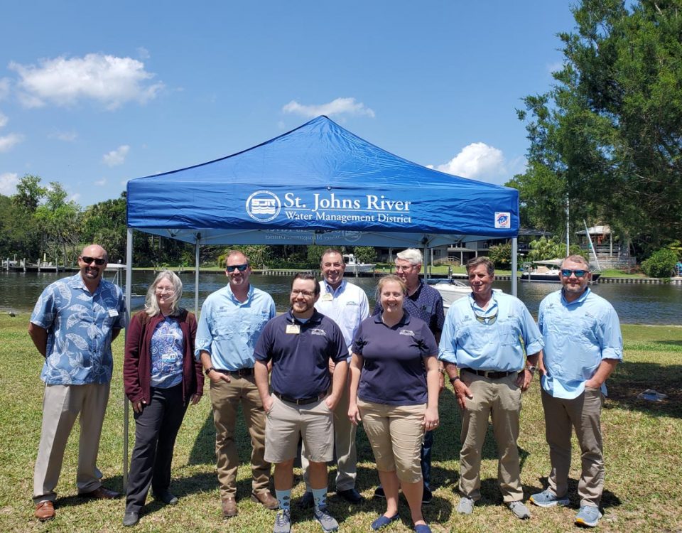 District staff and board members standing in front of a portable tent