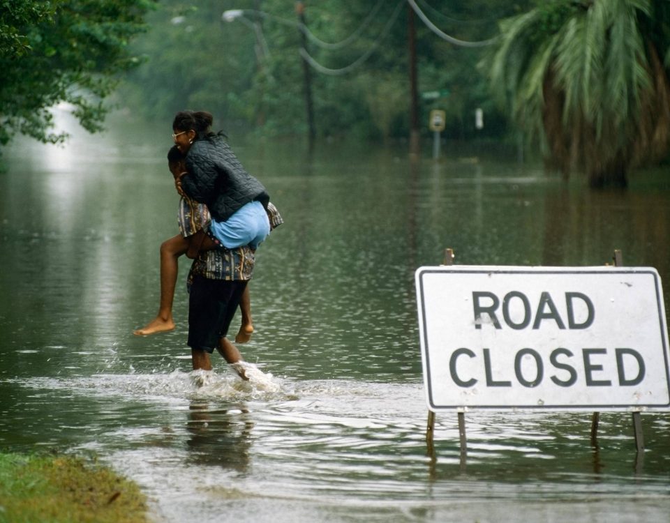 A person carying someone through highwaters