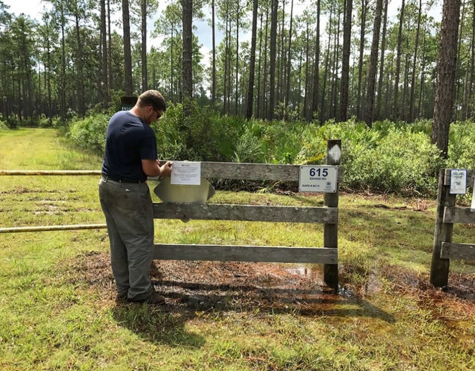 District employee putting a sign up on a fence