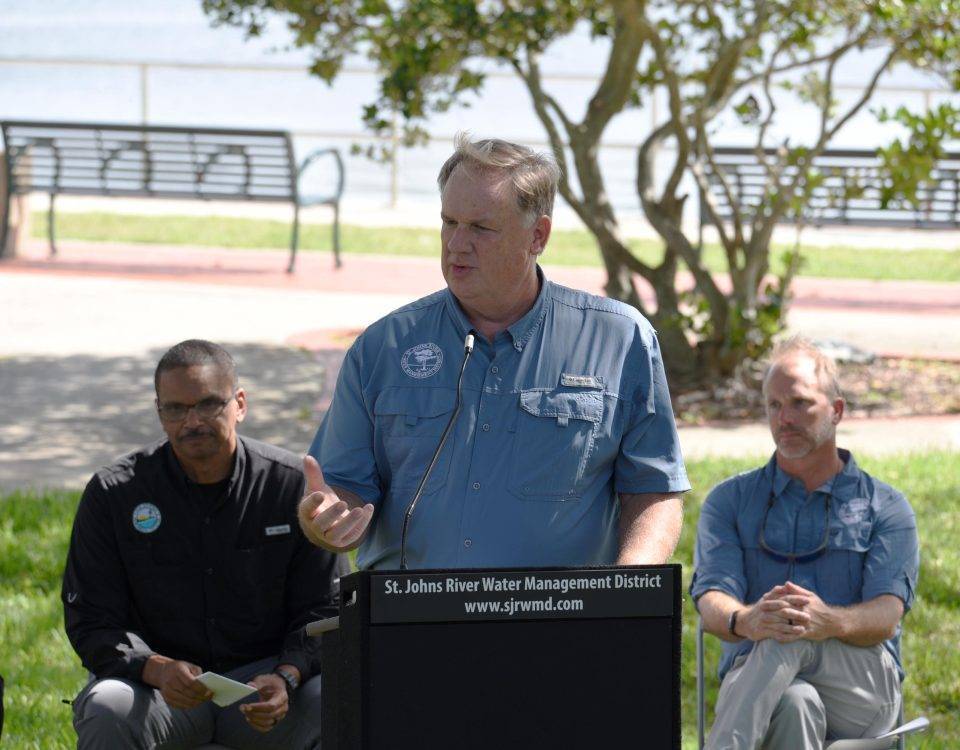 Mike Register welcomes guests at a podium